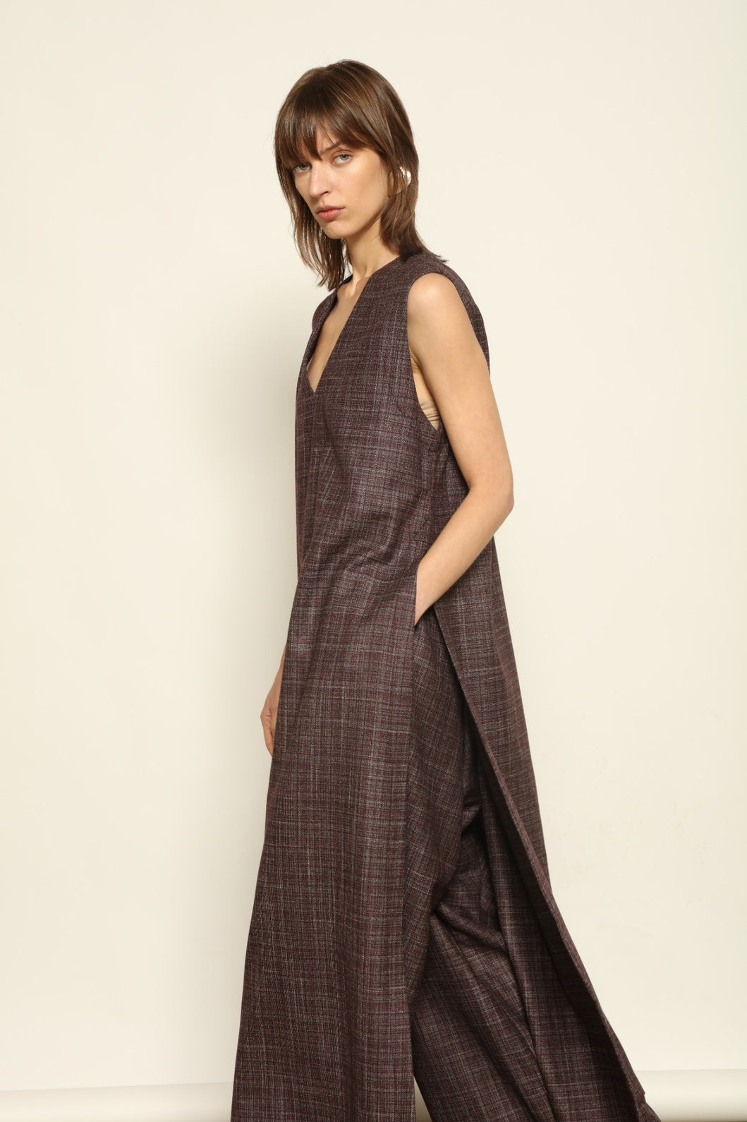 Model is wearing the Parigi Burgundy Lana Trousers by House of Woven Stories – Italian-tailored trousers crafted from a luxurious blend of merino wool, silk, and linen, featuring front pleats, side pockets, and a relaxed yet elegant burgundy silhouette.