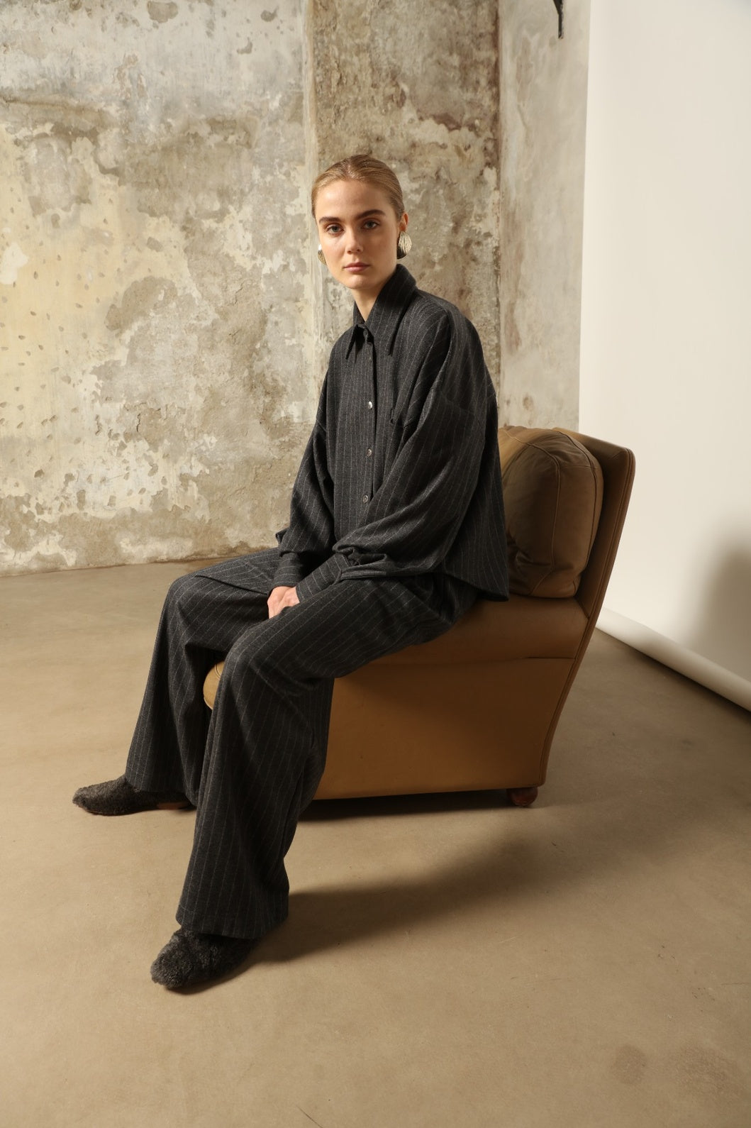 Model wearing Parigi Trousers in Double Jersey Striped Grey and White by House of Woven Stories, part of the curated selection, made in Italy from 100% Merino wool, featuring soft double jersey texture and elegant striped design for refined comfort and timeless style.