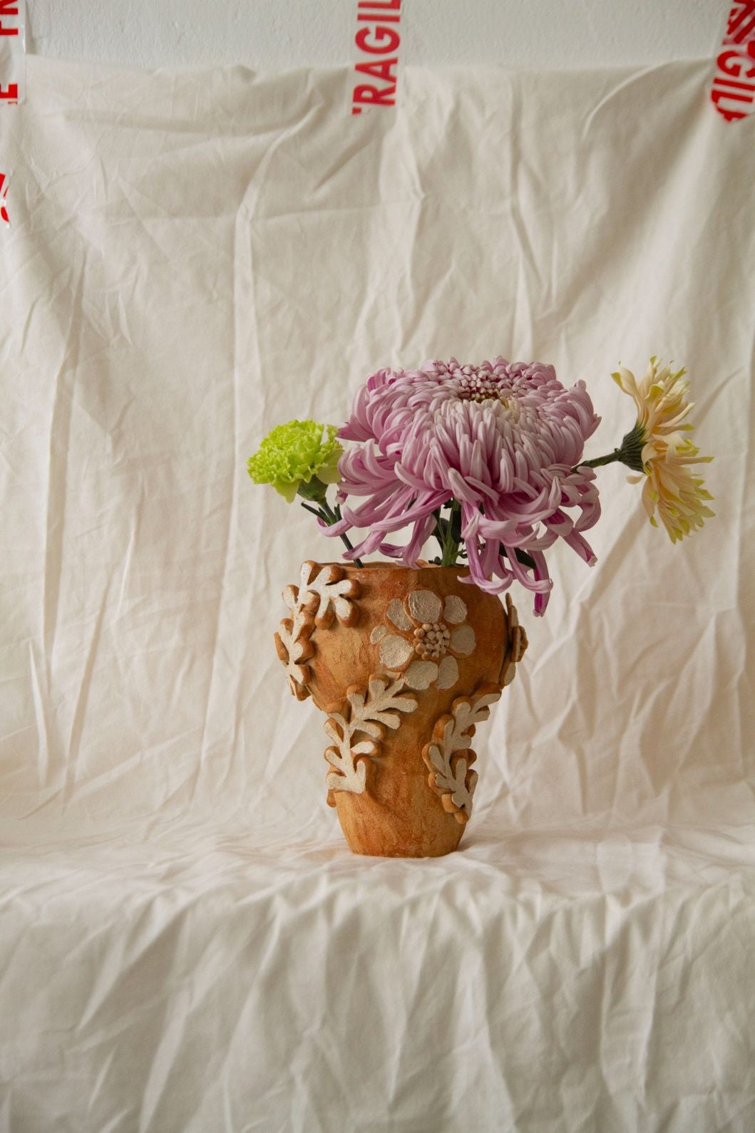 Petit Jardin n.05 by Clandestine Céramique, handmade in warm brown clay with a natural glossy glaze and hand-painted floral motifs, part of the House of Woven Stories selection.