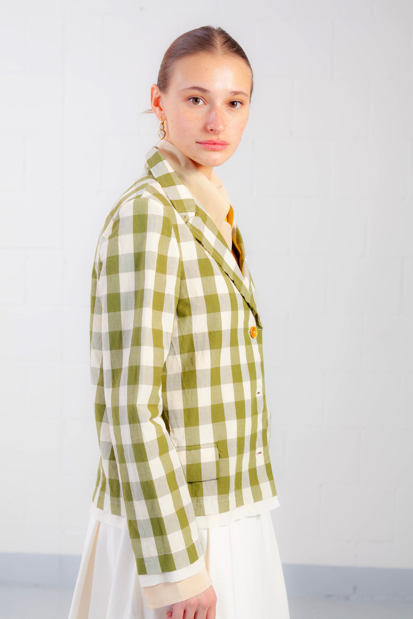 Model is wearing the Pine Checked Cotton and Linen Jacket by Balia 8.22, featuring a classic tailored fit, pine green and white checked pattern, and breathable Italian craftsmanship.