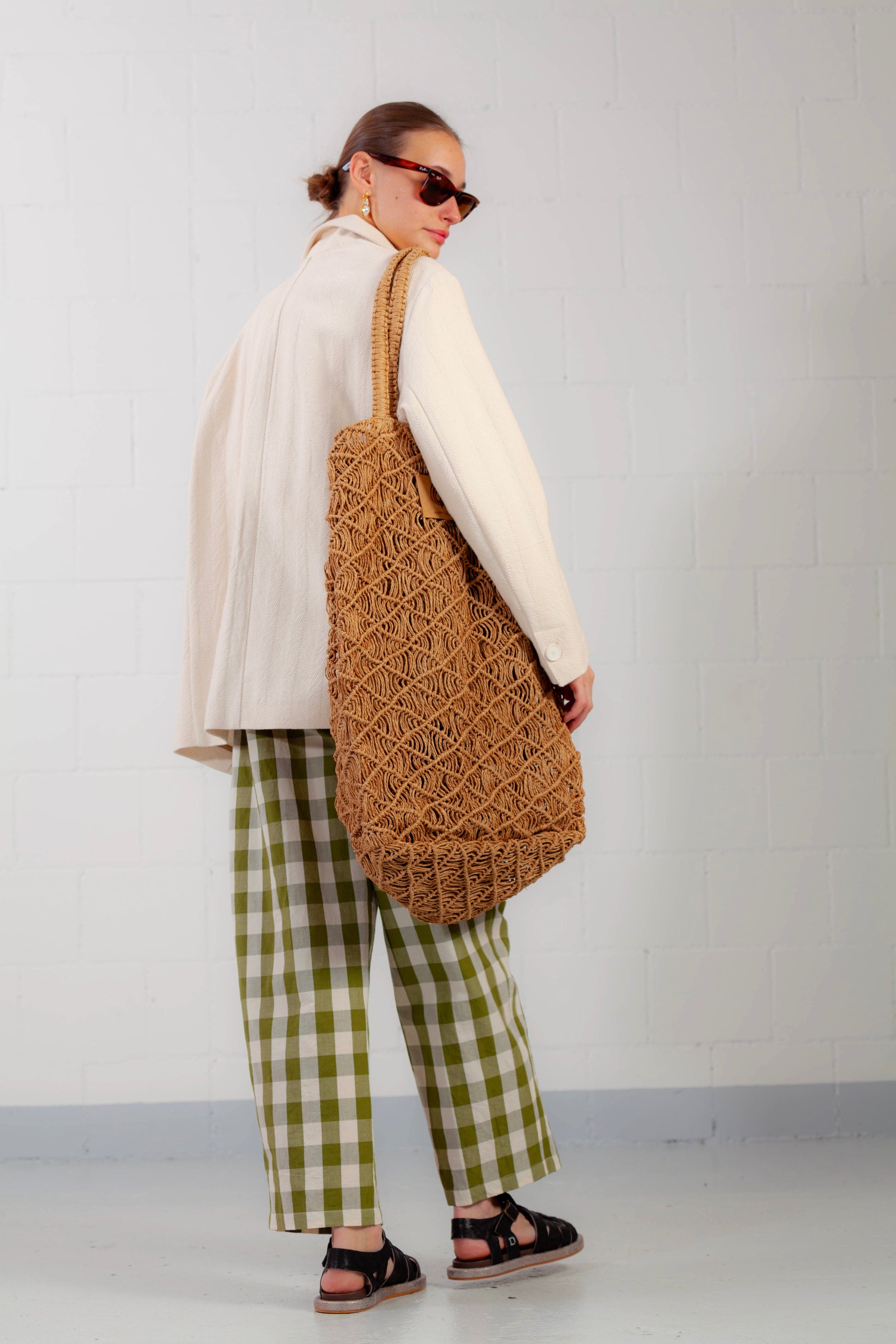 Model is wearing the Pine Checked Trousers by Balia 8.22, handcrafted in Italy from cotton and linen, featuring a relaxed straight-leg fit with pine green and white check pattern.