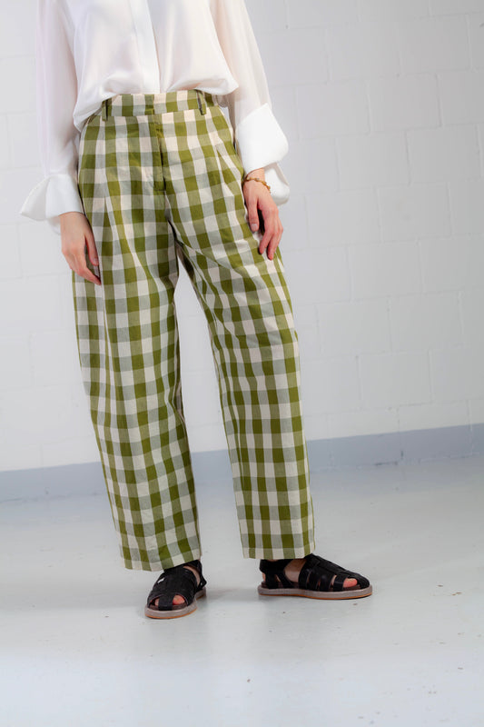 Model is wearing the Pine Checked Trousers by Balia 8.22, handcrafted in Italy from cotton and linen, featuring a relaxed straight-leg fit with pine green and white check pattern.
