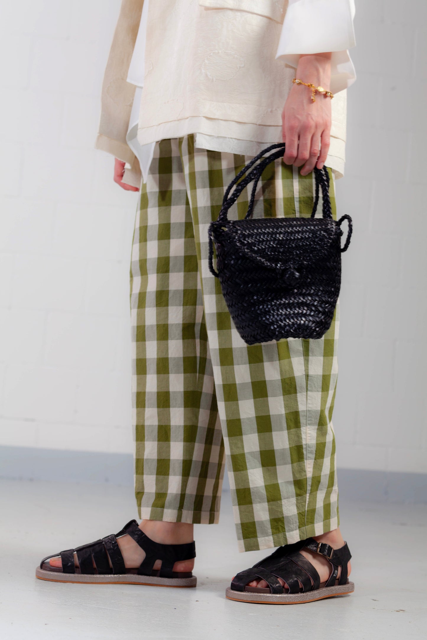 Model is wearing the Pine Checked Trousers by Balia 8.22, handcrafted in Italy from cotton and linen, featuring a relaxed straight-leg fit with pine green and white check pattern.