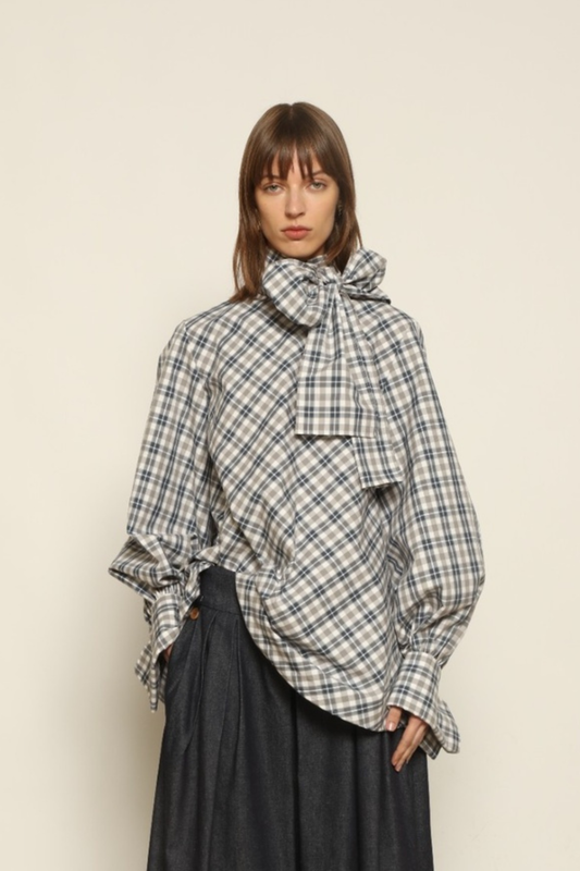 Model is wearing the Regula Maxi Check Popeline Cotton Blouse by House of Woven Stories, crafted from crisp poplin cotton in an oversized check pattern with a waist tie and buttoned cuffs.