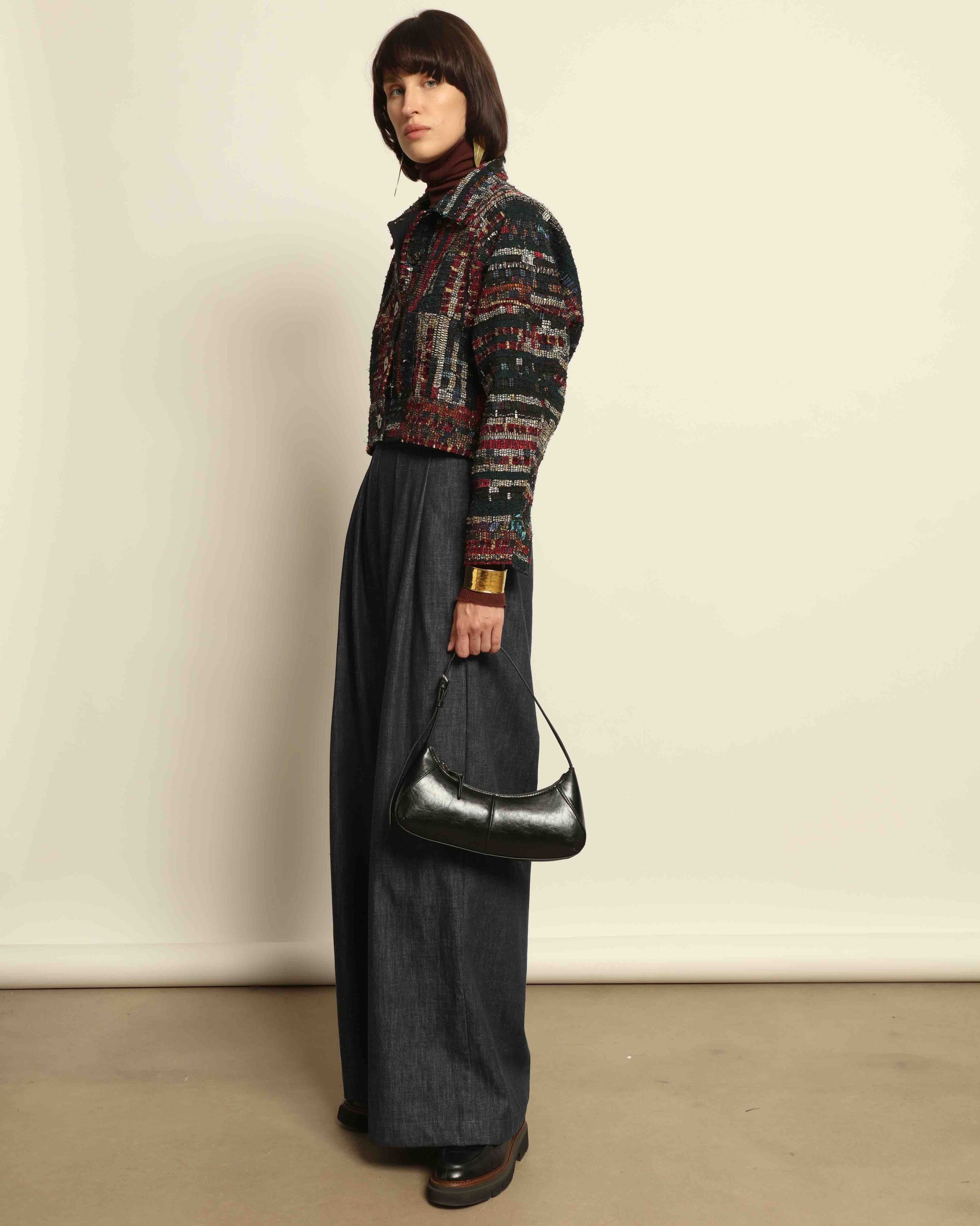 Model is wearing the Rewoven Hand-loomed Bomber by Paiwand, an upcycled unisex jacket crafted from handwoven organic cotton off-cuts with unique color and design variations.