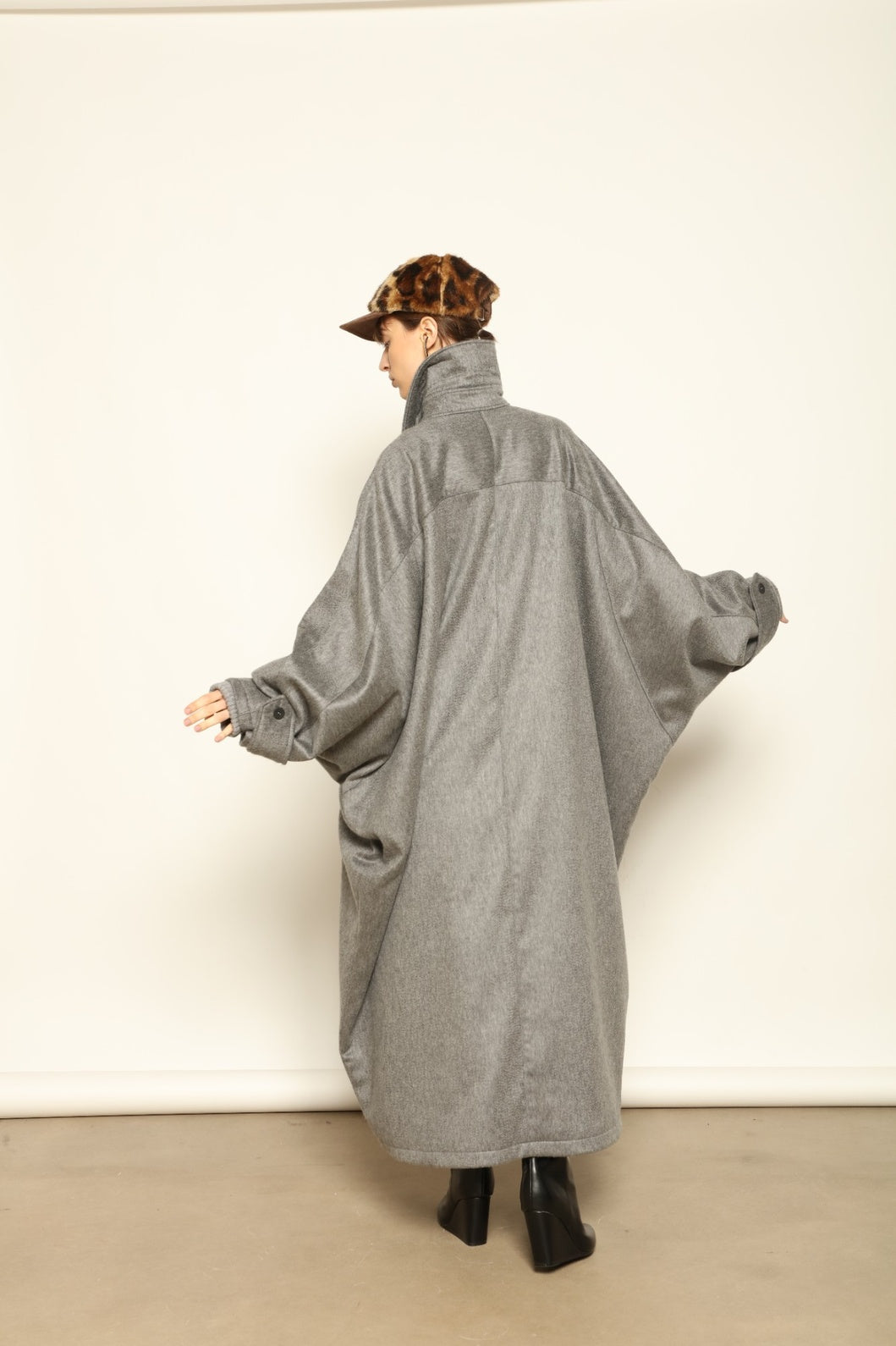 Model is wearing the Ryadh Long Coat in flannel grey by House of Woven Stories, made from merino wool and cashmere with silk lining and vintage 1960s buttons.