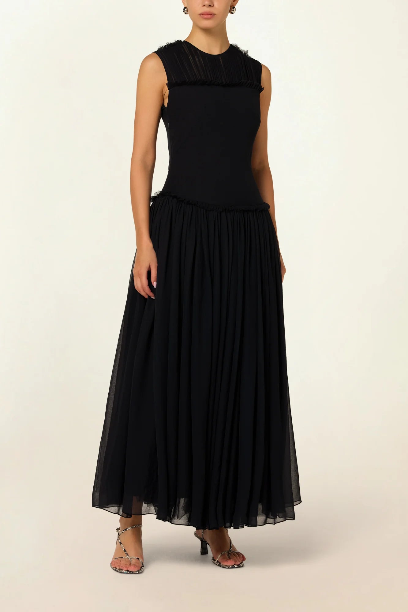 Model wearing a black silk Sera Dress by Abadia from the House of Nomad Stories collection, featuring a fitted bodice and fluid midi skirt with an elegant lightweight drape.