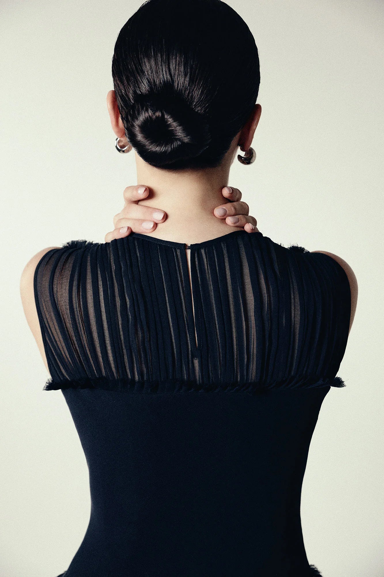 Model wearing a black silk Sera Dress by Abadia from the House of Nomad Stories collection, featuring a fitted bodice and fluid midi skirt with an elegant lightweight drape.