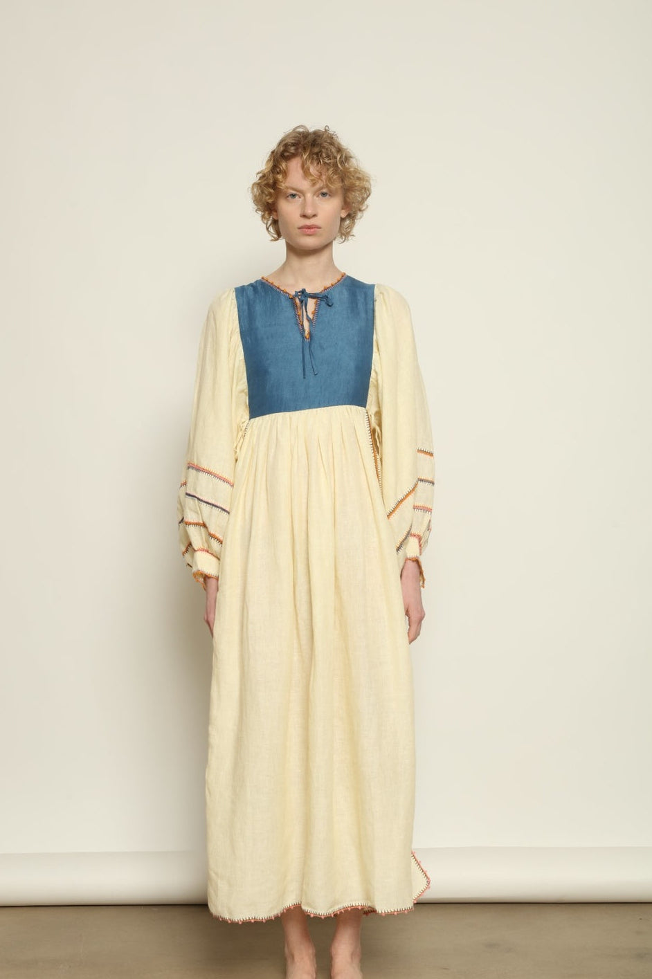 Model is wearing the Serafina Blue Linen Dress by Supernaturae x HONS, crafted in structured linen blended with hand-spun silk, featuring deep indigo botanical dye tones inspired by the sea. This sustainable slow fashion piece includes delicate hand-crochet edges and natural organic variations unique to each garment. Made in small-batch production in Mexico using ancestral techniques, part of the House of Woven Stories selection