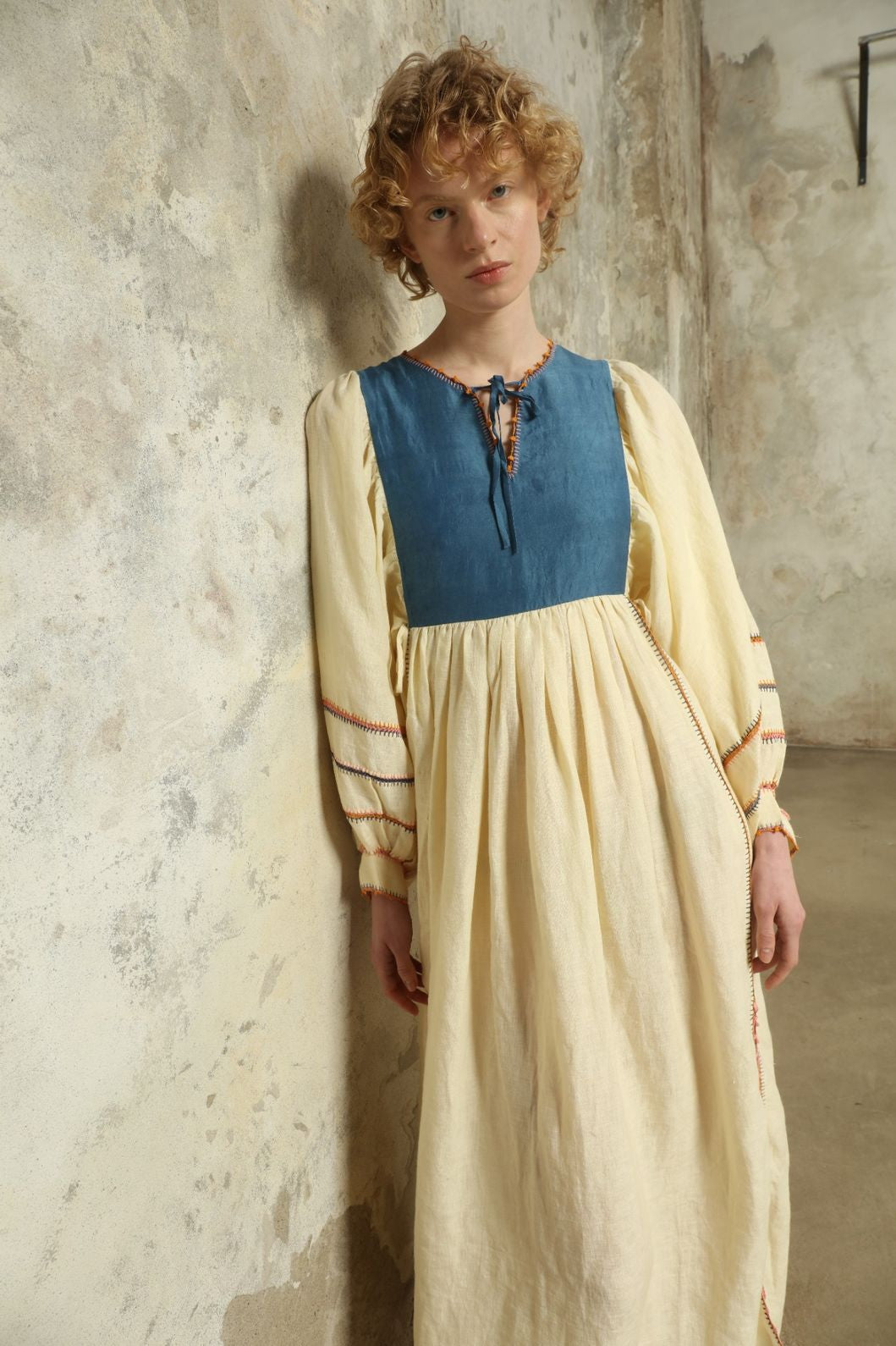 Model is wearing the Serafina Blue Linen Dress by Supernaturae x HONS, crafted in structured linen blended with hand-spun silk, featuring deep indigo botanical dye tones inspired by the sea. This sustainable slow fashion piece includes delicate hand-crochet edges and natural organic variations unique to each garment. Made in small-batch production in Mexico using ancestral techniques, part of the House of Woven Stories selection