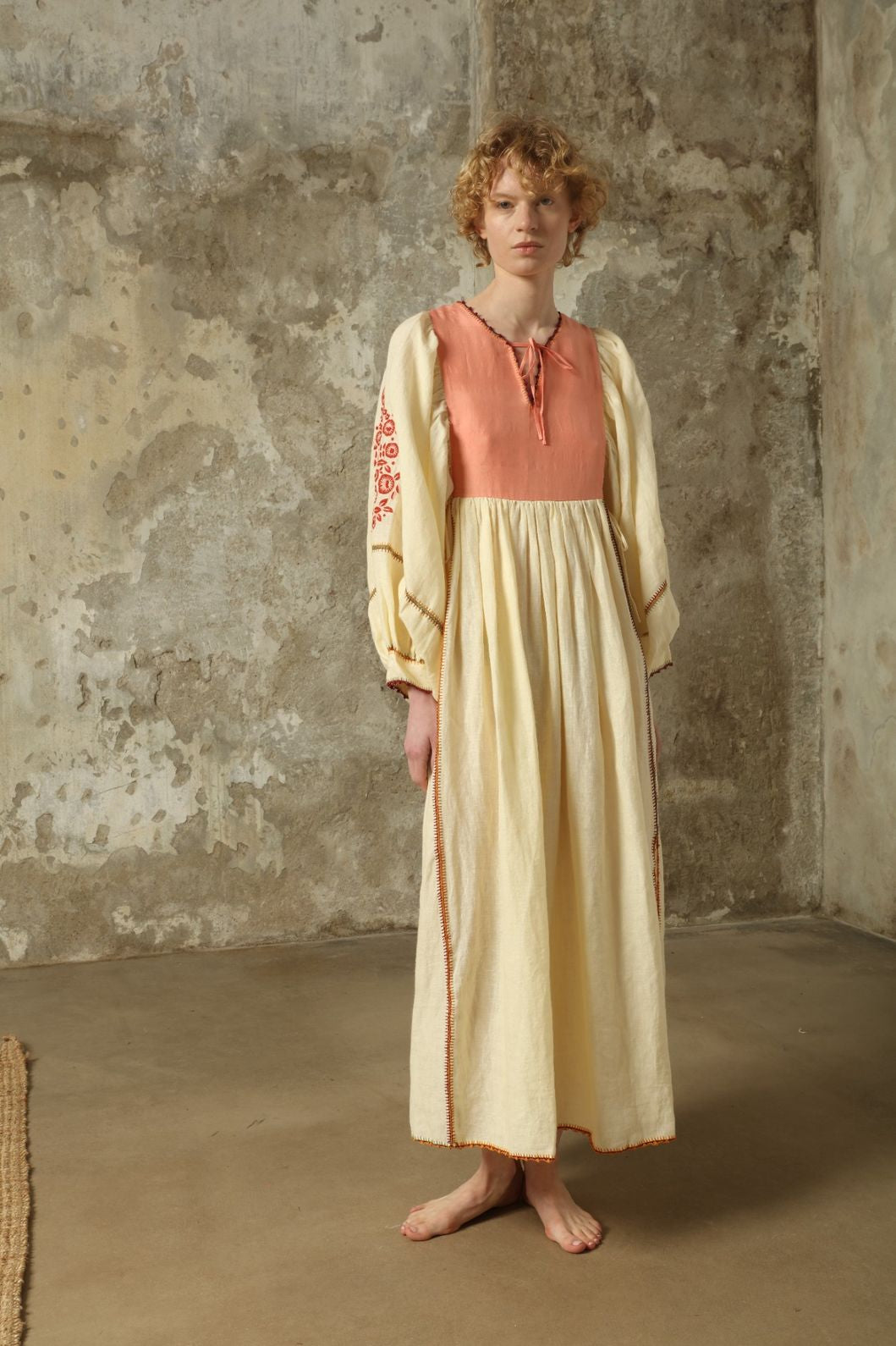 Model is wearing the Serafina Embroidered Rose Linen Dress by Supernaturae x HONS in soft earthy rose linen, featuring delicate hand embroidery across a breathable pure linen fabric. Part of the House of Woven Stories selection, this ethical artisan-crafted dress reflects ancestral techniques and sustainable production, with subtle natural variations in texture and stitch, designed in a relaxed fluid silhouette, worn by model 1.79m size S.