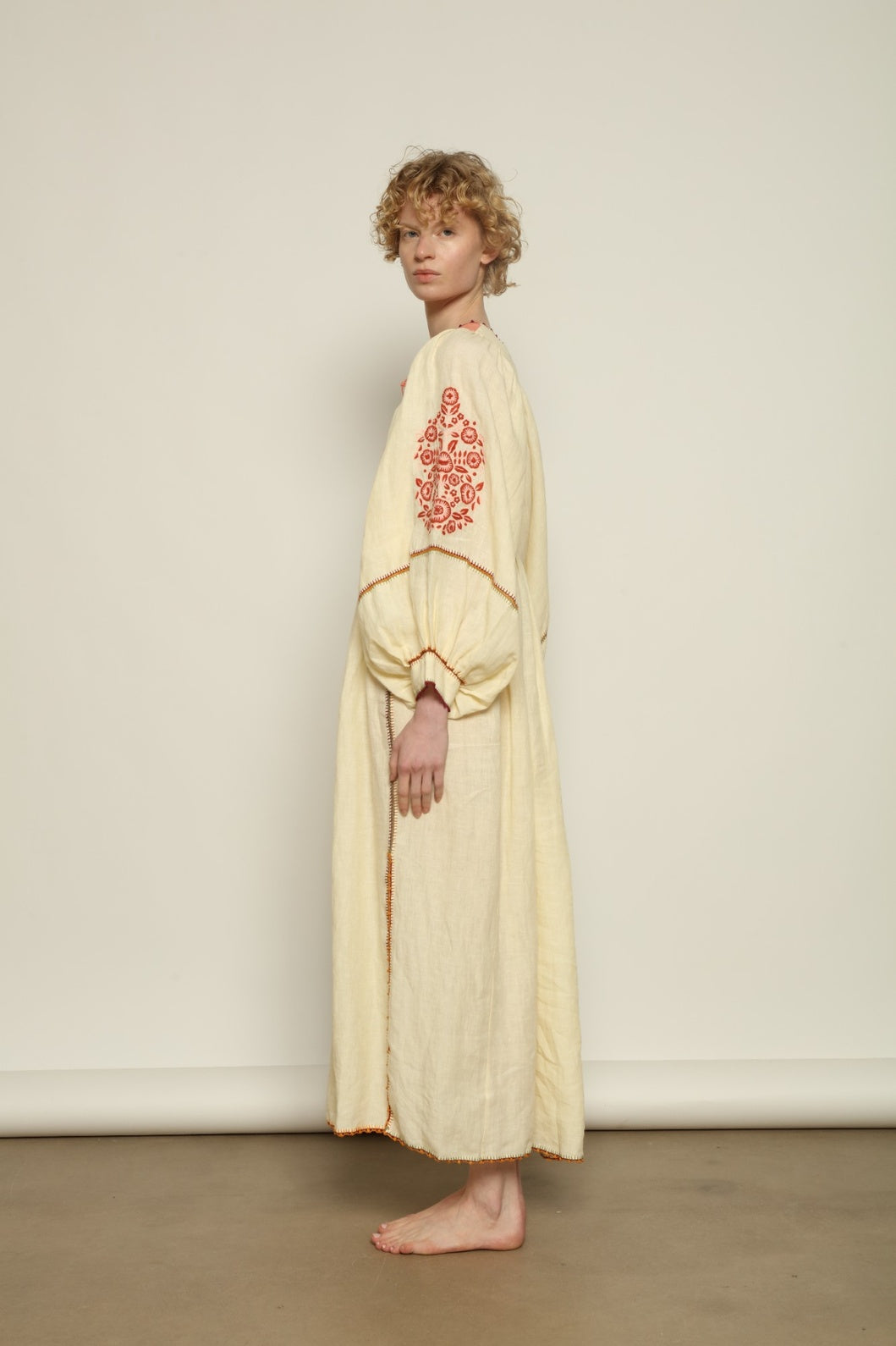Model is wearing the Serafina Embroidered Rose Linen Dress by Supernaturae x HONS in soft earthy rose linen, featuring delicate hand embroidery across a breathable pure linen fabric. Part of the House of Woven Stories selection, this ethical artisan-crafted dress reflects ancestral techniques and sustainable production, with subtle natural variations in texture and stitch, designed in a relaxed fluid silhouette, worn by model 1.79m size S.