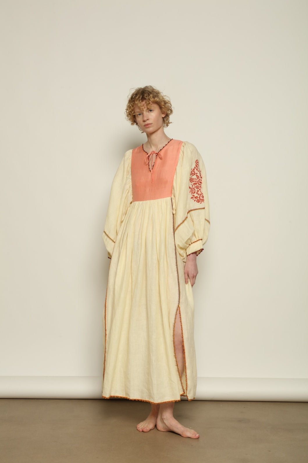 Model is wearing the Serafina Embroidered Rose Linen Dress by Supernaturae x HONS in soft earthy rose linen, featuring delicate hand embroidery across a breathable pure linen fabric. Part of the House of Woven Stories selection, this ethical artisan-crafted dress reflects ancestral techniques and sustainable production, with subtle natural variations in texture and stitch, designed in a relaxed fluid silhouette, worn by model 1.79m size S.