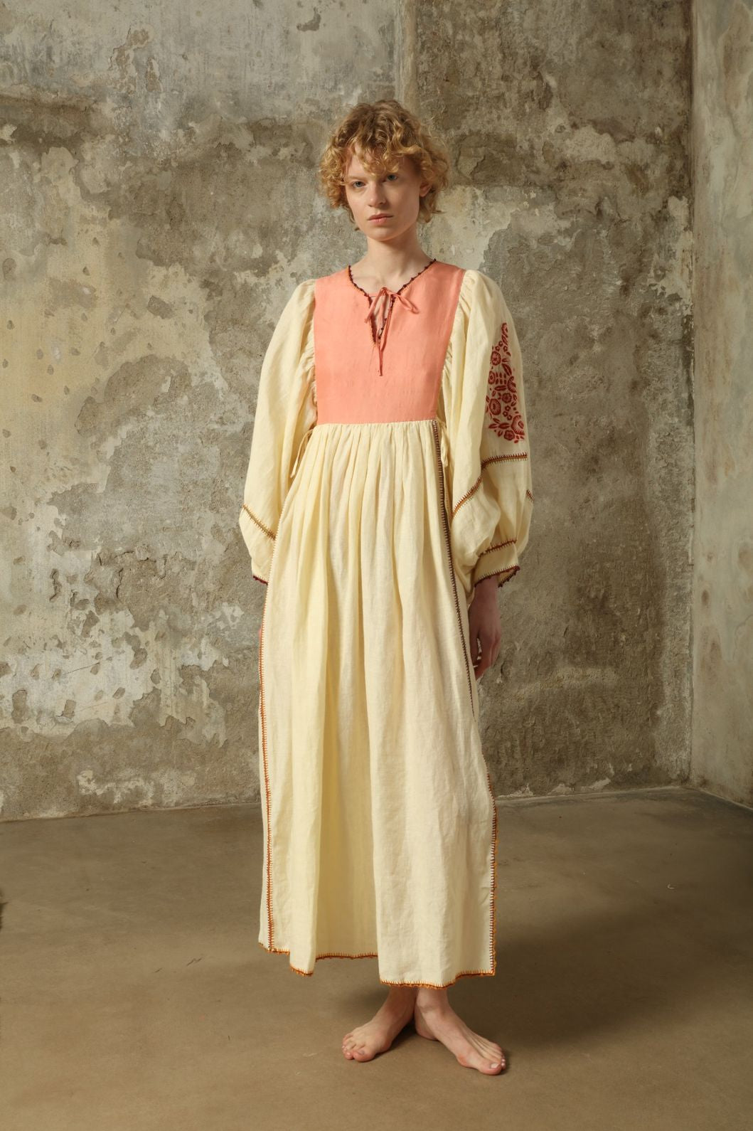 Model is wearing the Serafina Embroidered Rose Linen Dress by Supernaturae x HONS in soft earthy rose linen, featuring delicate hand embroidery across a breathable pure linen fabric. Part of the House of Woven Stories selection, this ethical artisan-crafted dress reflects ancestral techniques and sustainable production, with subtle natural variations in texture and stitch, designed in a relaxed fluid silhouette, worn by model 1.79m size S.
