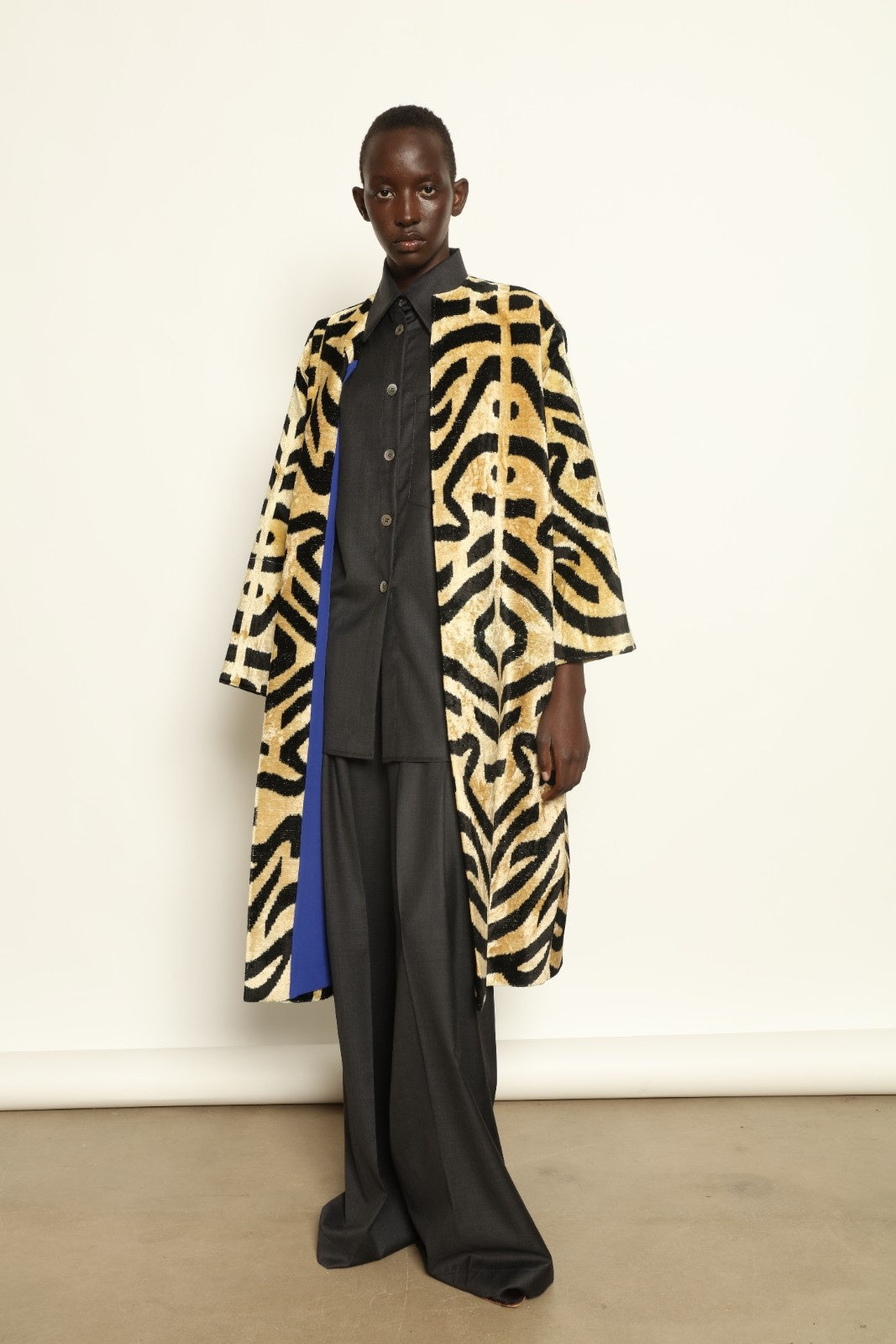Model is wearing the Serai Ikat Velvet Coat by Aleksandra Viktor, part of House of Woven Stories collection, handwoven Uzbek ikat velvet coat with bold geometric pattern and cobalt lining
