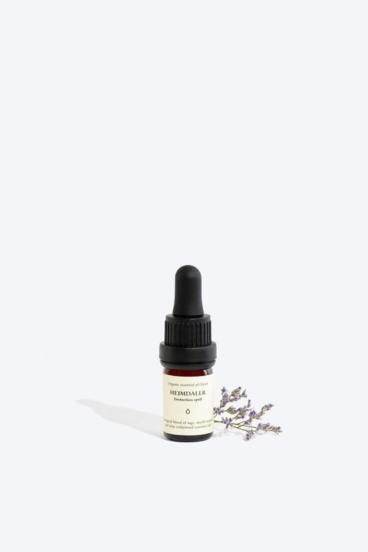Organic essential oil blend Heimdallr by Smells Like Spells in a glass bottle with dropper, designed for protection and home energy cleansing, offered by House of Woven Stories.