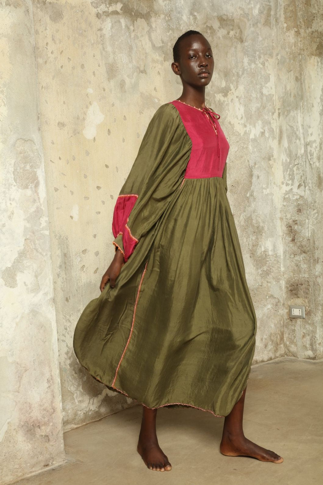 Model Hawa wearing the Serafina Olive Silk Dress by Supernaturae, a handcrafted silk dress with botanical dyes, hand-crochet edges and flowing 1970s-inspired silhouette.