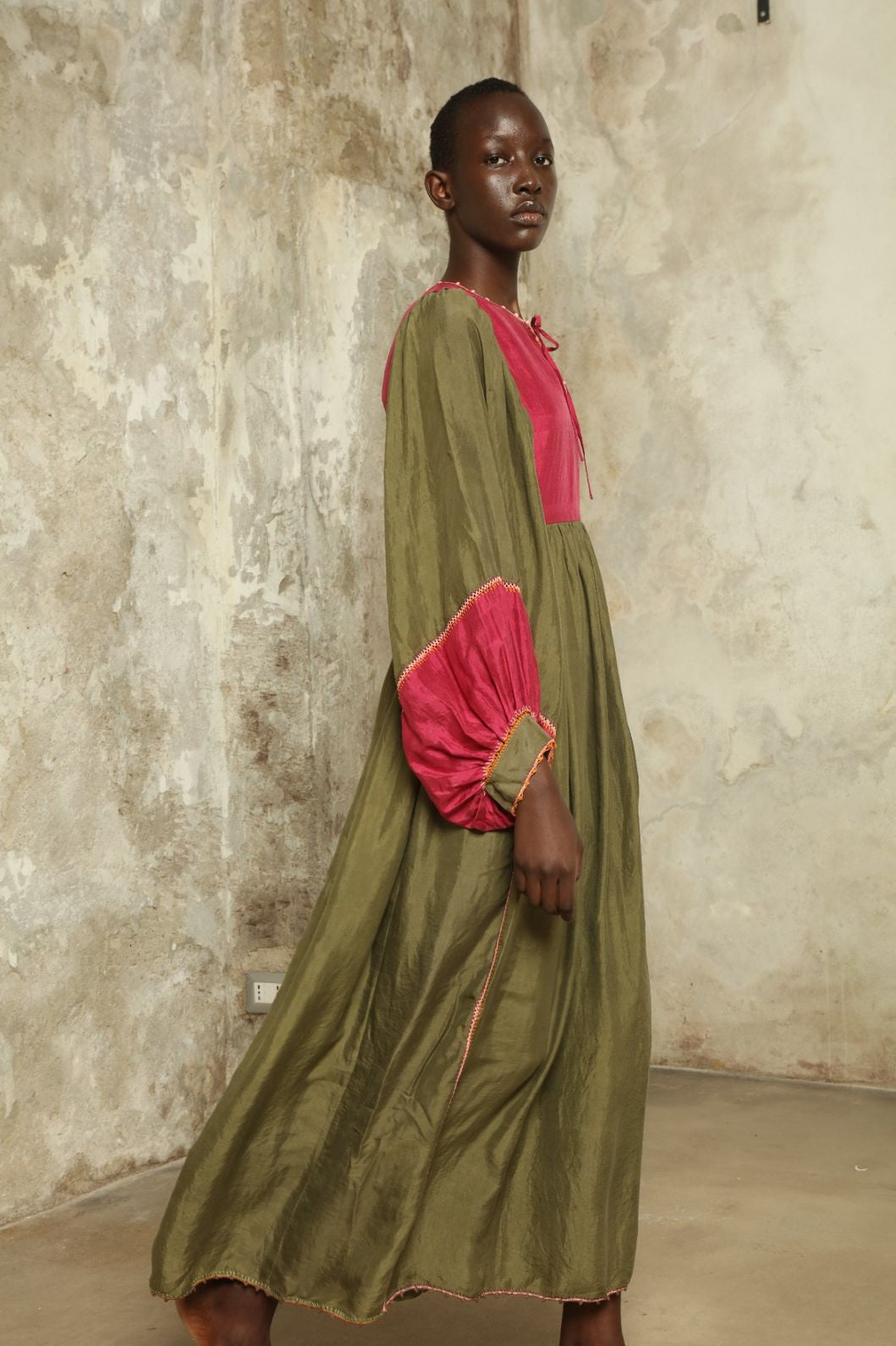 Model Hawa wearing the Serafina Olive Silk Dress by Supernaturae, a handcrafted silk dress with botanical dyes, hand-crochet edges and flowing 1970s-inspired silhouette.