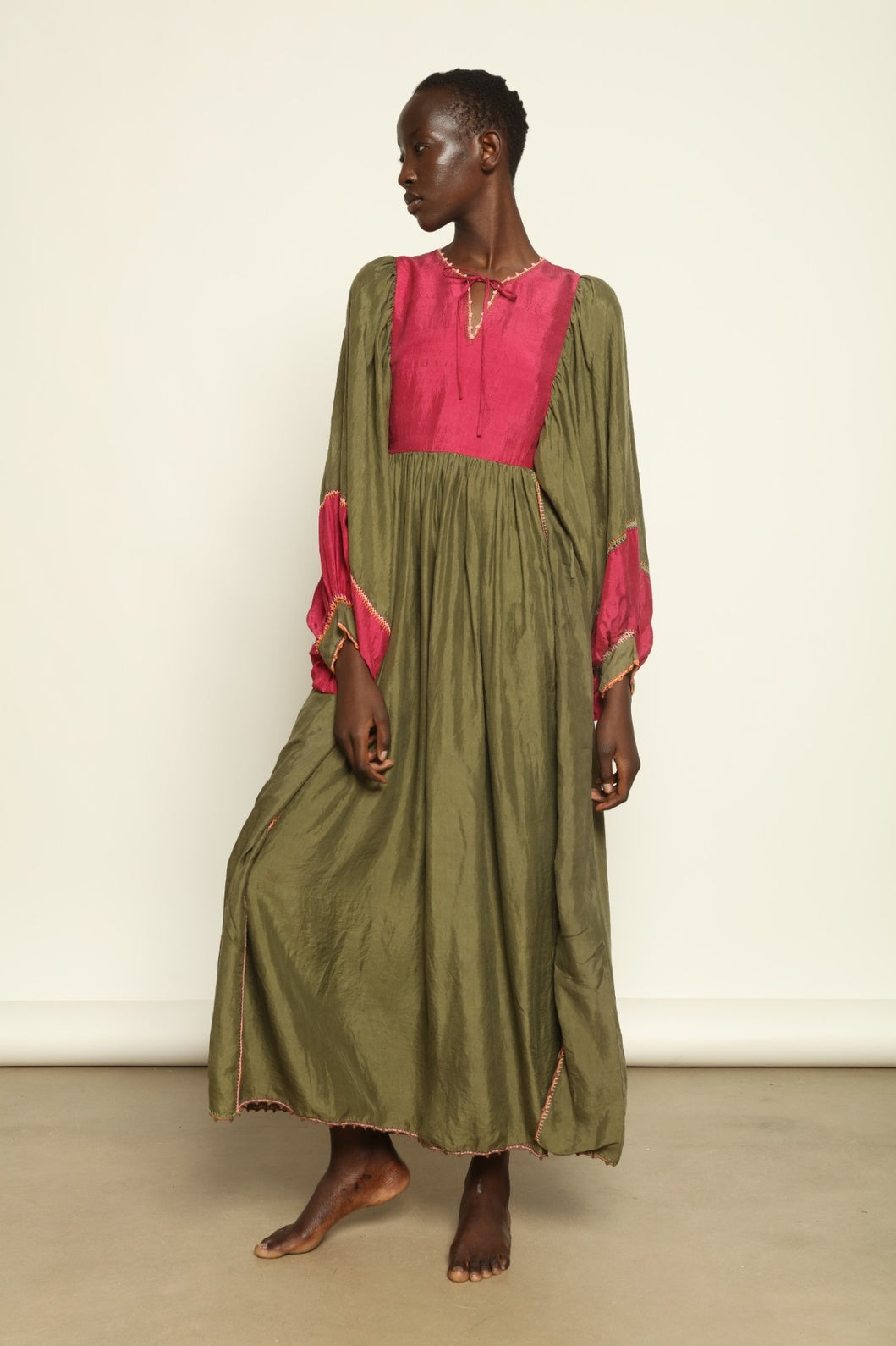 Model Hawa wearing the Serafina Olive Silk Dress by Supernaturae, a handcrafted silk dress with botanical dyes, hand-crochet edges and flowing 1970s-inspired silhouette.