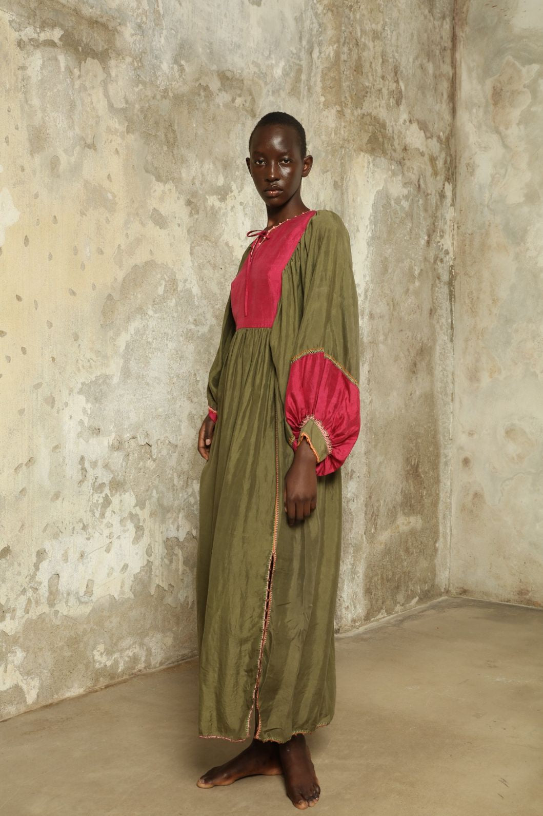 Model Hawa wearing the Serafina Olive Silk Dress by Supernaturae, a handcrafted silk dress with botanical dyes, hand-crochet edges and flowing 1970s-inspired silhouette.