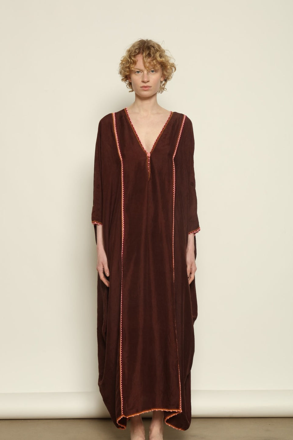 Model is wearing the Thea Brown Silk Dress by Supernaturae x HONS in rich earthy brown handwoven silk from Murshidabad, featuring a soft open back and flowing silhouette. Botanical dyed with natural pigments, this sustainable slow luxury dress shows subtle tonal variations and artisanal craftsmanship, part of the House of Woven Stories selection