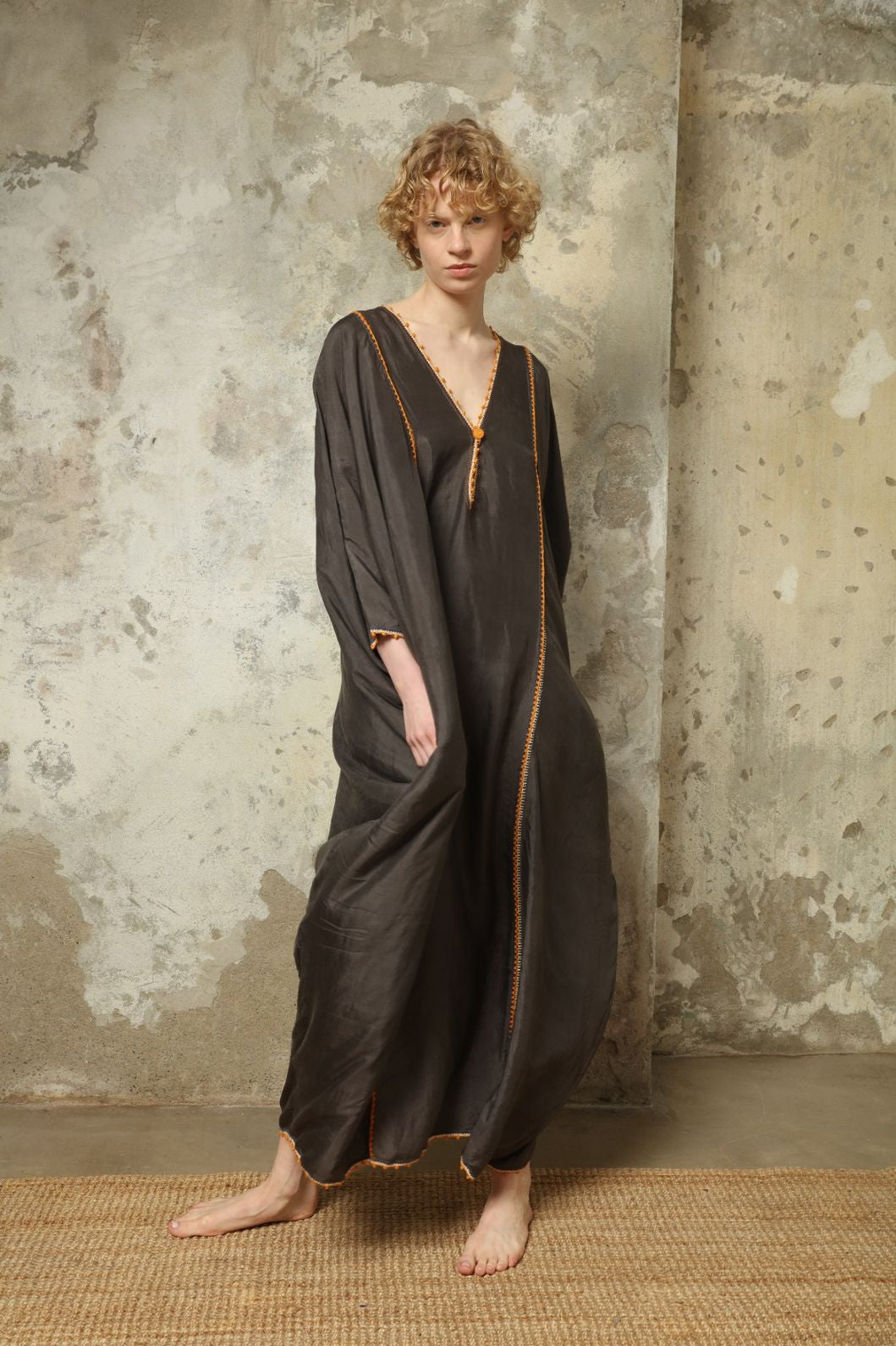 Model is wearing the Thea Grey Silk Dress by Supernaturae x HONS, crafted in handwoven silk from Murshidabad, featuring a relaxed flowing silhouette, elegant open back and natural hand-dyed grey tones. Part of the House of Woven Stories selection