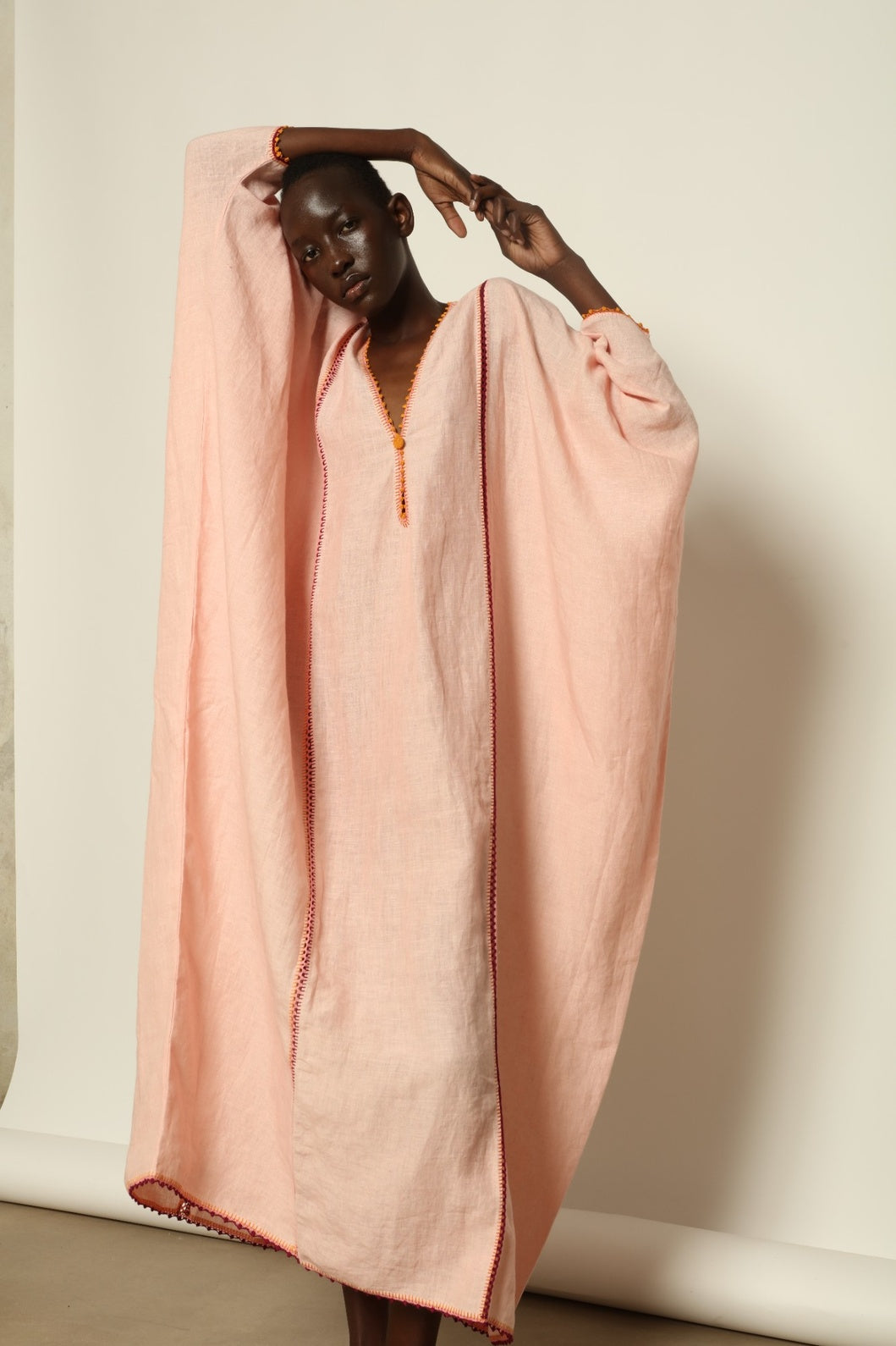 Model is wearing the Thea Pink Linen Dress by Supernaturae x HONS in soft botanical hibiscus pink linen, featuring a relaxed oversized silhouette, open back detail and breathable sustainable fabric. Part of the House of Woven Stories curated selection.