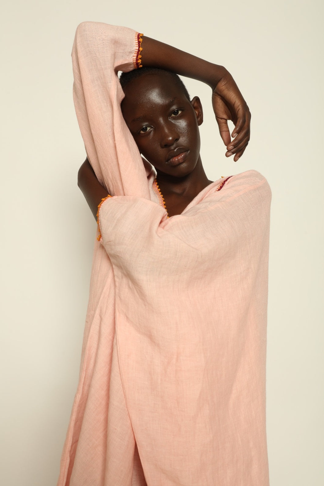 Model is wearing the Thea Pink Linen Dress by Supernaturae x HONS in soft botanical hibiscus pink linen, featuring a relaxed oversized silhouette, open back detail and breathable sustainable fabric. Part of the House of Woven Stories curated selection.
