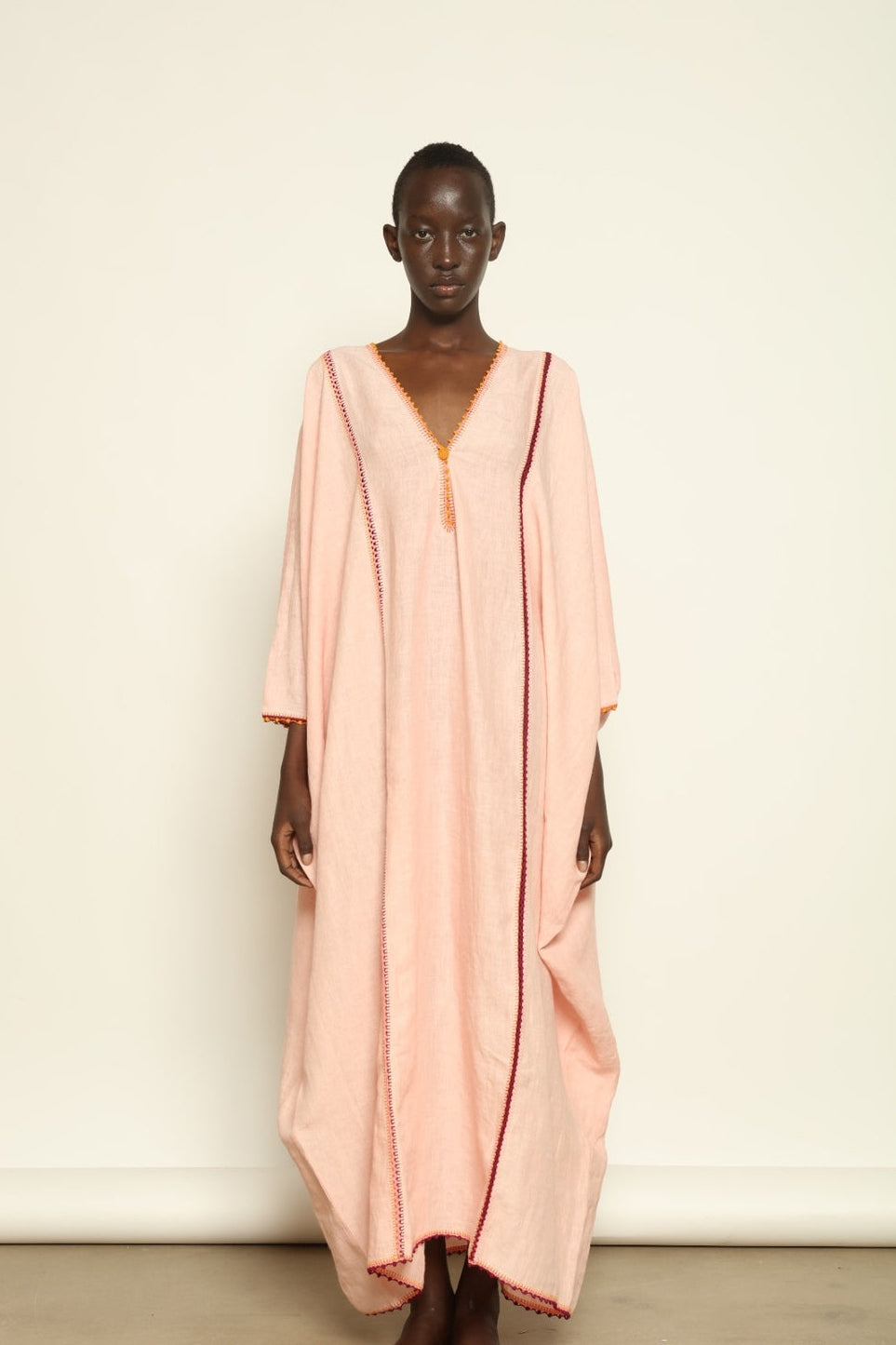 Model is wearing the Thea Pink Linen Dress by Supernaturae x HONS in soft botanical hibiscus pink linen, featuring a relaxed oversized silhouette, open back detail and breathable sustainable fabric. Part of the House of Woven Stories curated selection.