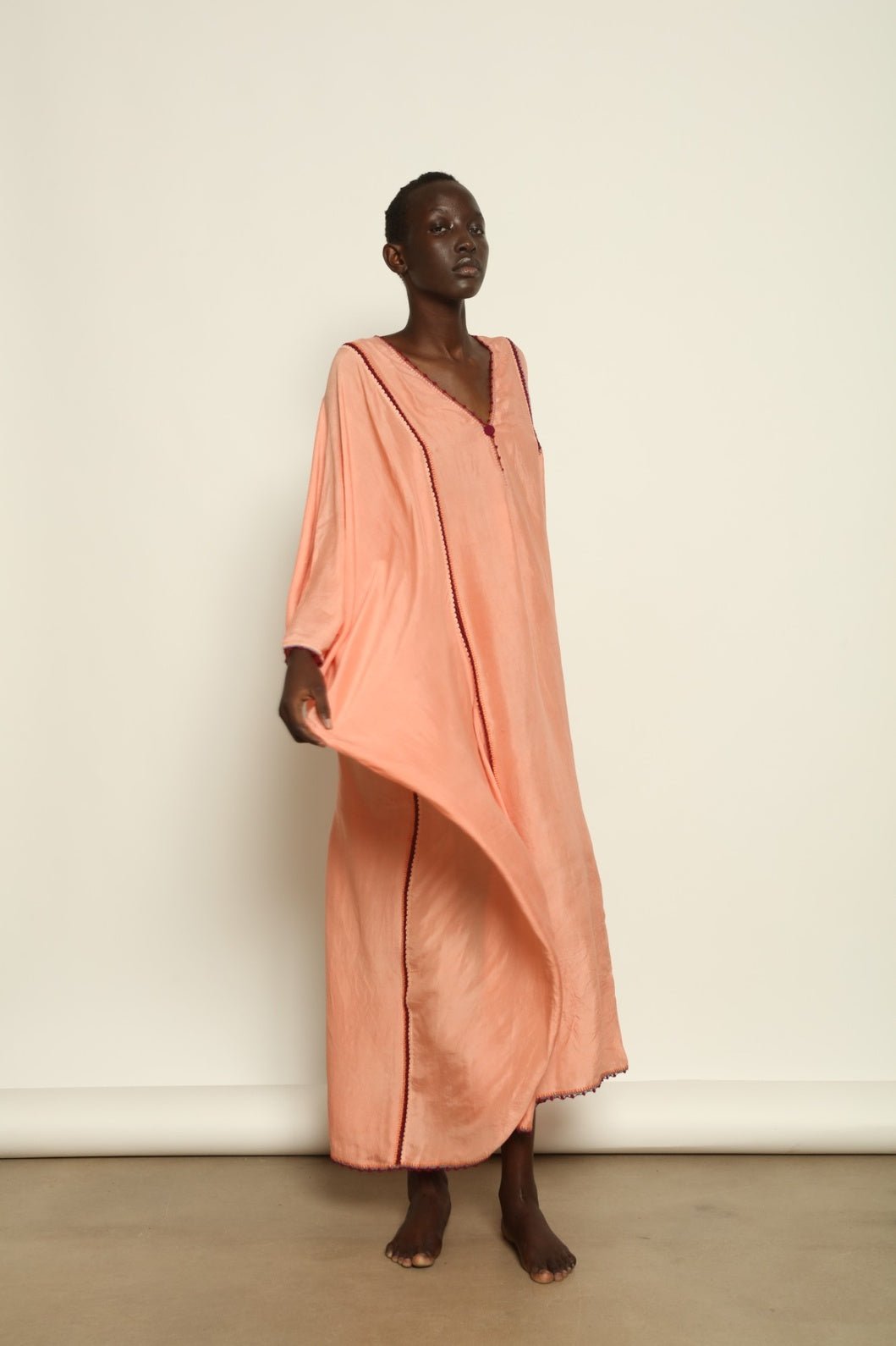 Model is wearing the Thea Rose Silk Dress by Supernaturae x HONS, crafted in handwoven silk from Murshidabad with a soft botanical rose dye finish, featuring a relaxed flowing silhouette and deep open back design. Part of the House of Woven Stories selection, this sustainable slow luxury piece reflects ethical artisan craftsmanship and natural dye variations.