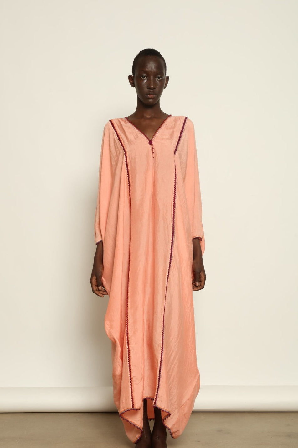 Model is wearing the Thea Rose Silk Dress by Supernaturae x HONS, crafted in handwoven silk from Murshidabad with a soft botanical rose dye finish, featuring a relaxed flowing silhouette and deep open back design. Part of the House of Woven Stories selection, this sustainable slow luxury piece reflects ethical artisan craftsmanship and natural dye variations.