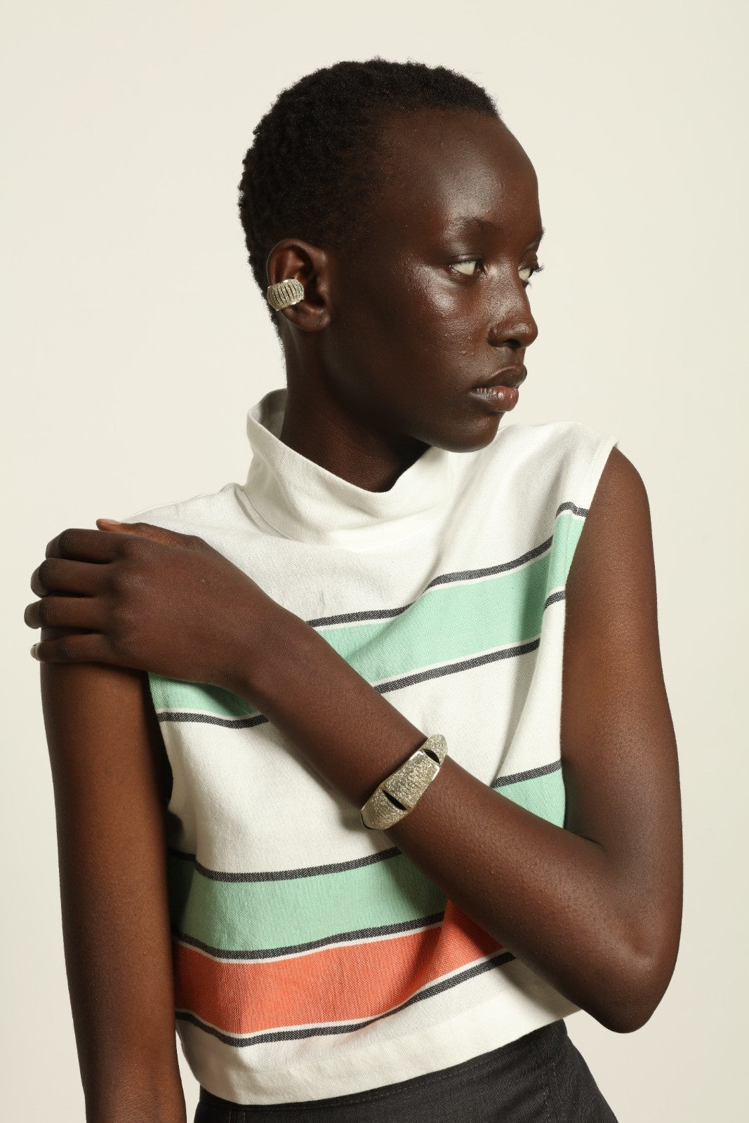 Model is wearing The Cropped Turtleneck by Marrakshi Life, part of House of Nomad Stories collection, handwoven artisanal cotton top with boxy architectural silhouette, high turtleneck, and breathable weave