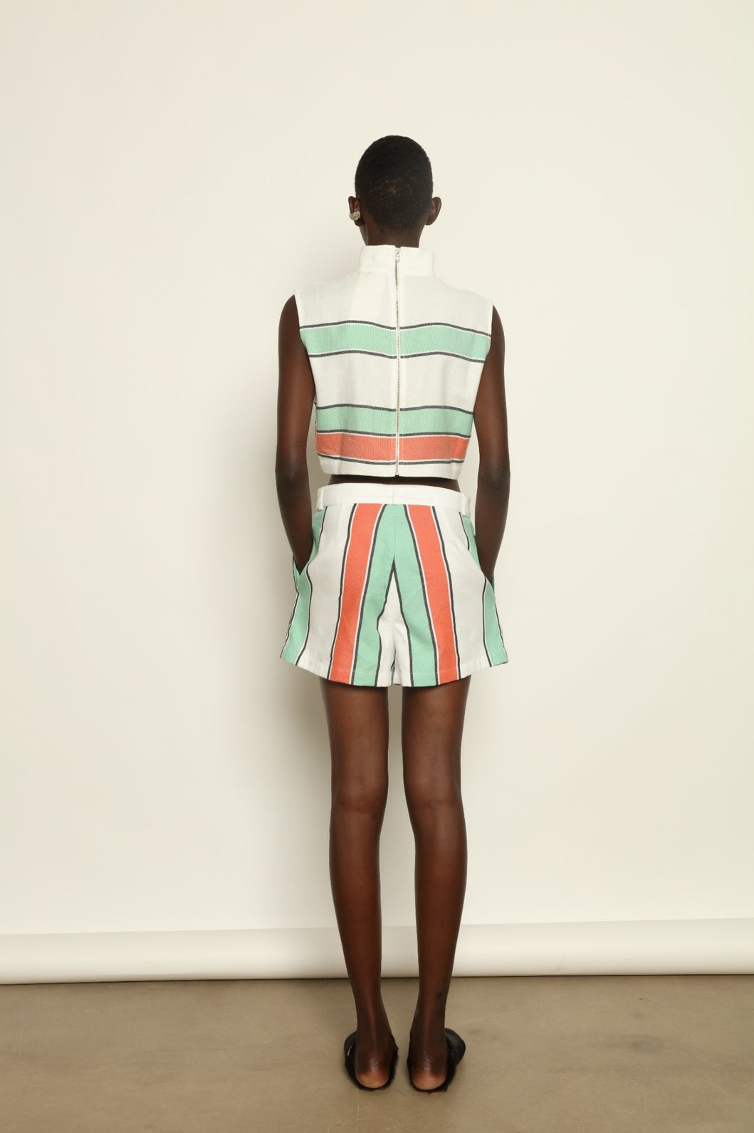 Model is wearing The Pleated Short by Marrakshi Life, part of House of Nomad Stories collection, handwoven artisanal cotton shorts with deep front pleats, high waist, and relaxed sculptural silhouette
