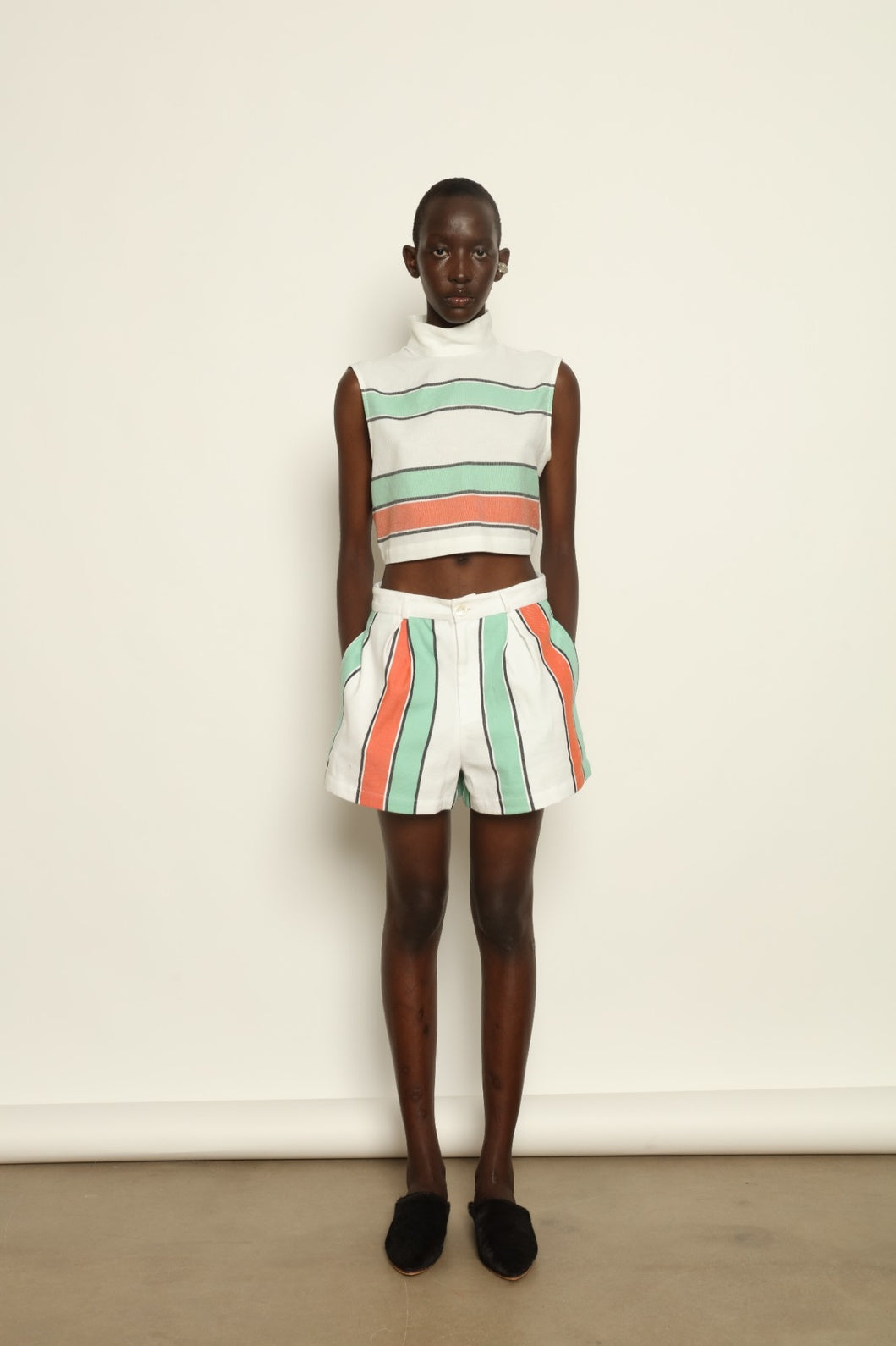 Model is wearing The Pleated Short by Marrakshi Life, part of House of Nomad Stories collection, handwoven artisanal cotton shorts with deep front pleats, high waist, and relaxed sculptural silhouette