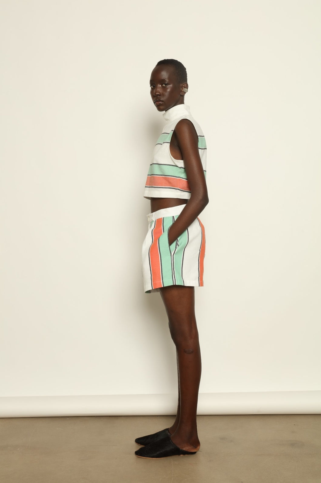 Model is wearing The Pleated Short by Marrakshi Life, part of House of Nomad Stories collection, handwoven artisanal cotton shorts with deep front pleats, high waist, and relaxed sculptural silhouette