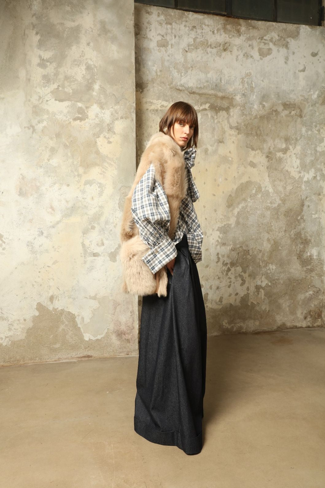 Model is wearing the Toscana Sabbia Shearling Vest by Blancha – a 100% Toscana sheepskin vest made in Italy, featuring a soft natural texture, warm drape, and refined Sabbia tone, styled for effortless layering and timeless elegance.