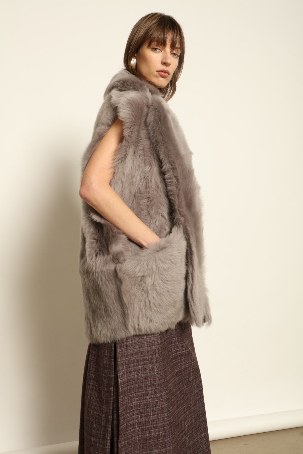 Model is wearing the Toscana Storm Shearling Vest by Blancha, crafted from 100% Toscana sheepskin in the Storm shade with soft, luxurious texture and Italian craftsmanship.