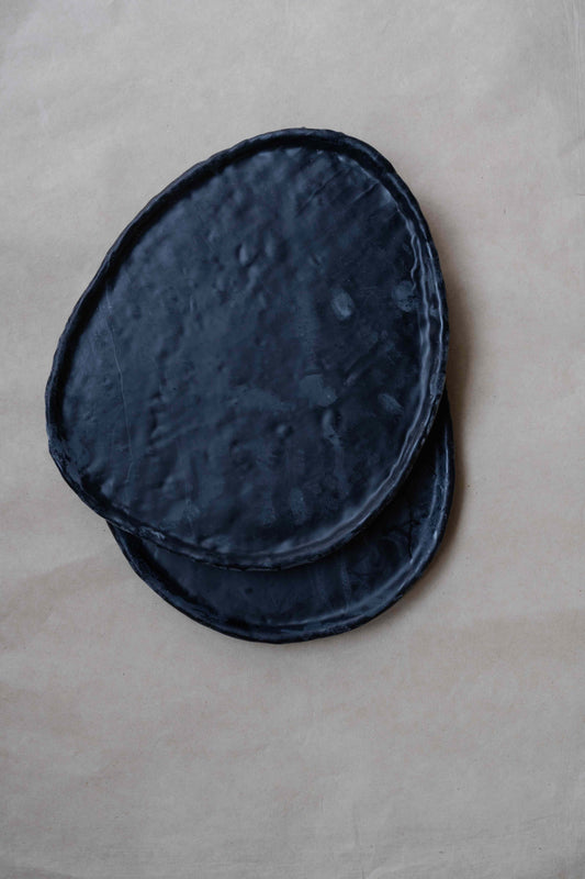 Tray Oval in Black by Oberflacht, part of the House of Woven Stories selection, handcrafted from beeswax and paraffin with smooth matte finish and unique variations in colour and texture.