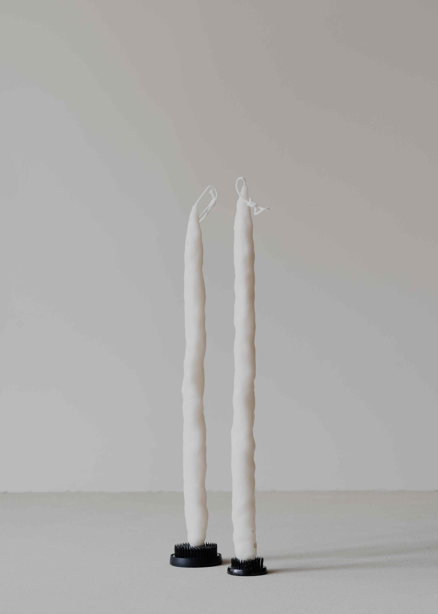 Twig Pair in Cream by Oberflacht, part of the House of Woven Stories selection, handcrafted from beeswax and paraffin with slender organic shape and subtle variations in colour and texture.