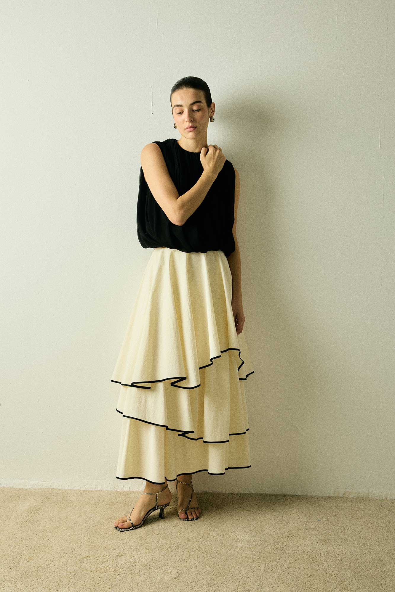 Model wearing a black Twisted Bubble Top by Abadia from the House of Nomad Stories collection, featuring sculptural volume, twisted front detail, and a bold yet refined silhouette.