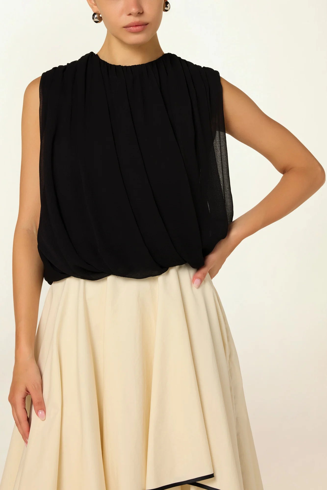 Model wearing a black Twisted Bubble Top by Abadia from the House of Nomad Stories collection, featuring sculptural volume, twisted front detail, and a bold yet refined silhouette.