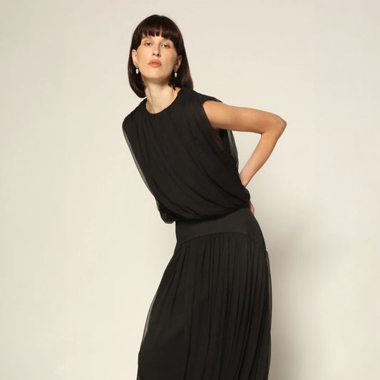 Model wearing a black Twisted Bubble Top by Abadia from the House of Nomad Stories collection, featuring sculptural volume, twisted front detail, and a bold yet refined silhouette.