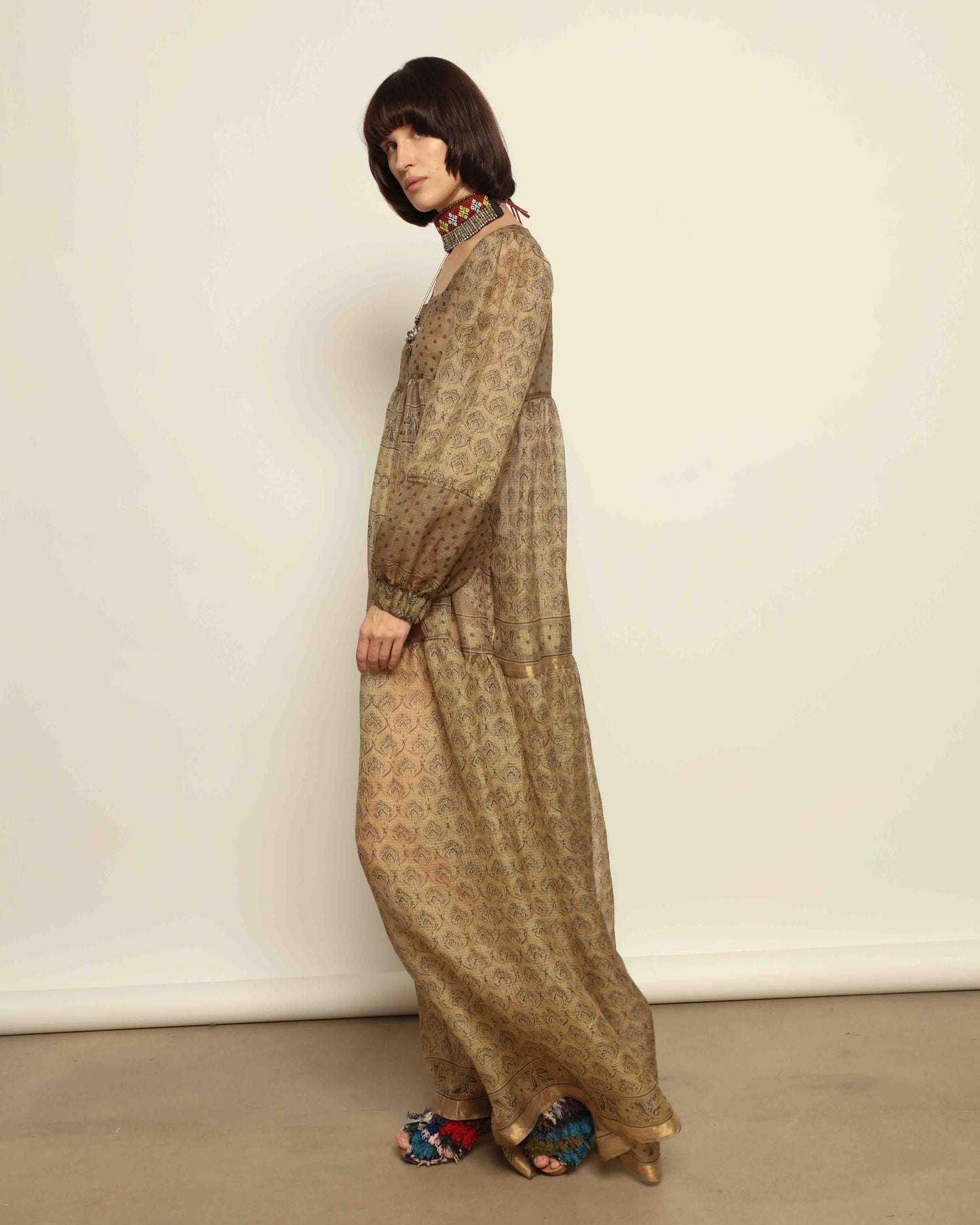 Model is wearing vintage-inspired maxi dress in lightweight 100% silk chiffon with square neckline, voluminous sleeves, and delicate all-over print. Part of House of Woven Stories selection.