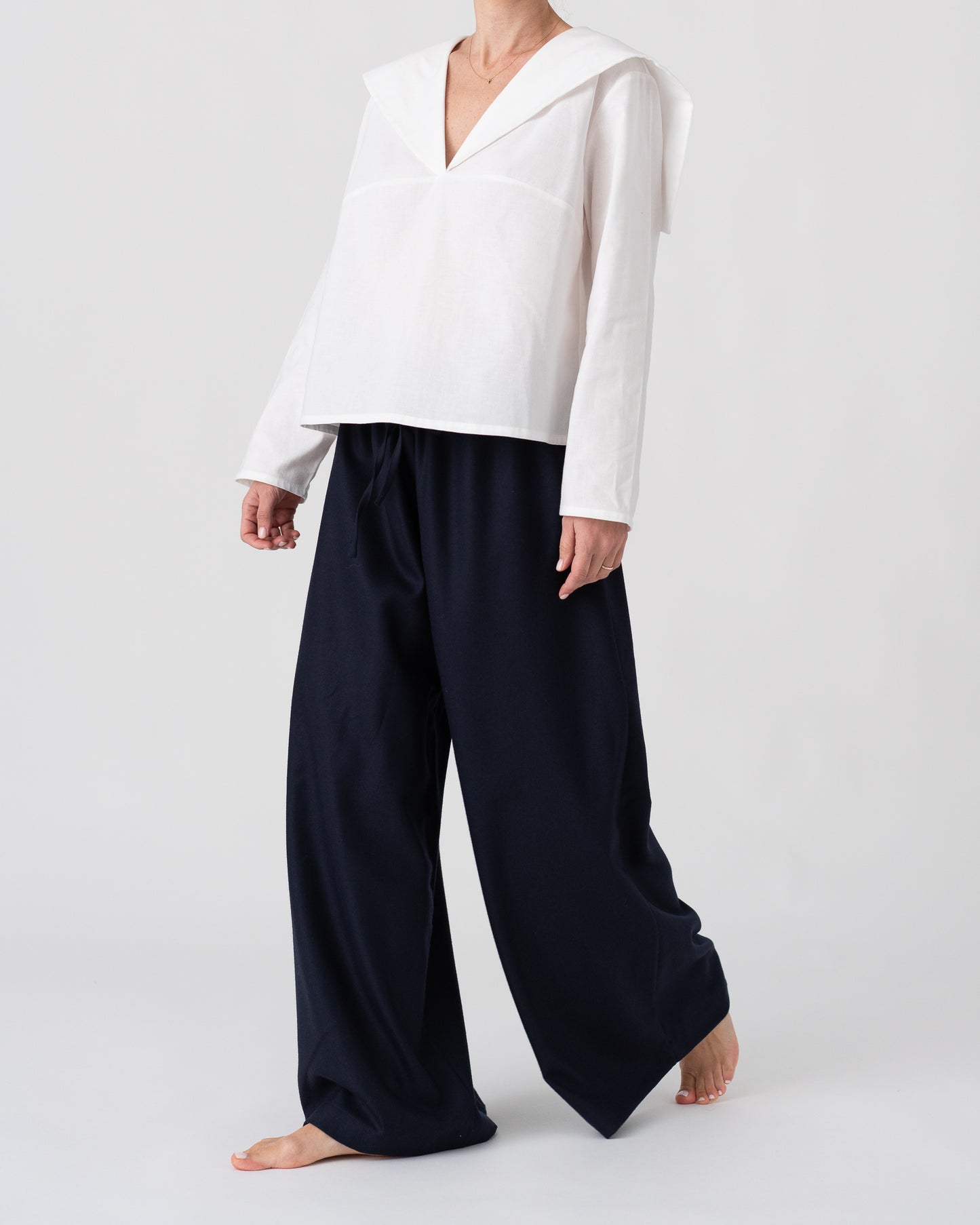 Model is wearing the Wool Black Pantalons by Les Vacances d’Irina, wide-leg handmade jersey-knit wool pants with adjustable drawstring waist and side pockets, available at House of Woven Stories.
