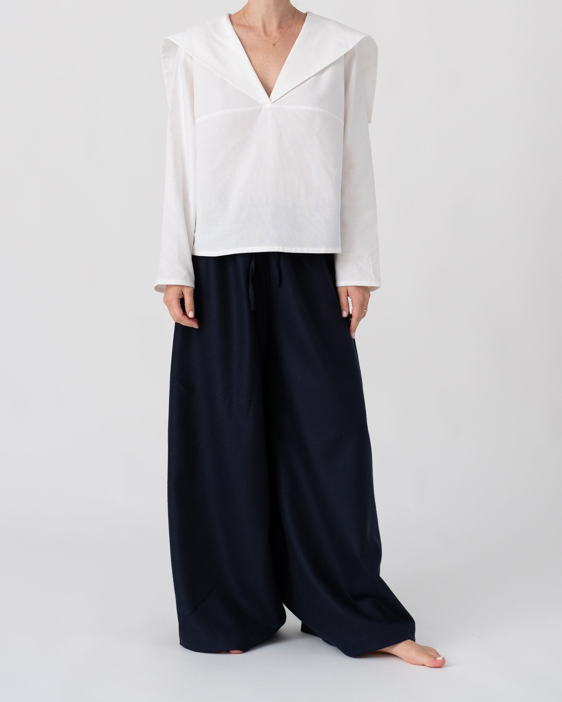 Model is wearing the Wool Black Pantalons by Les Vacances d’Irina, wide-leg handmade jersey-knit wool pants with adjustable drawstring waist and side pockets, available at House of Woven Stories.