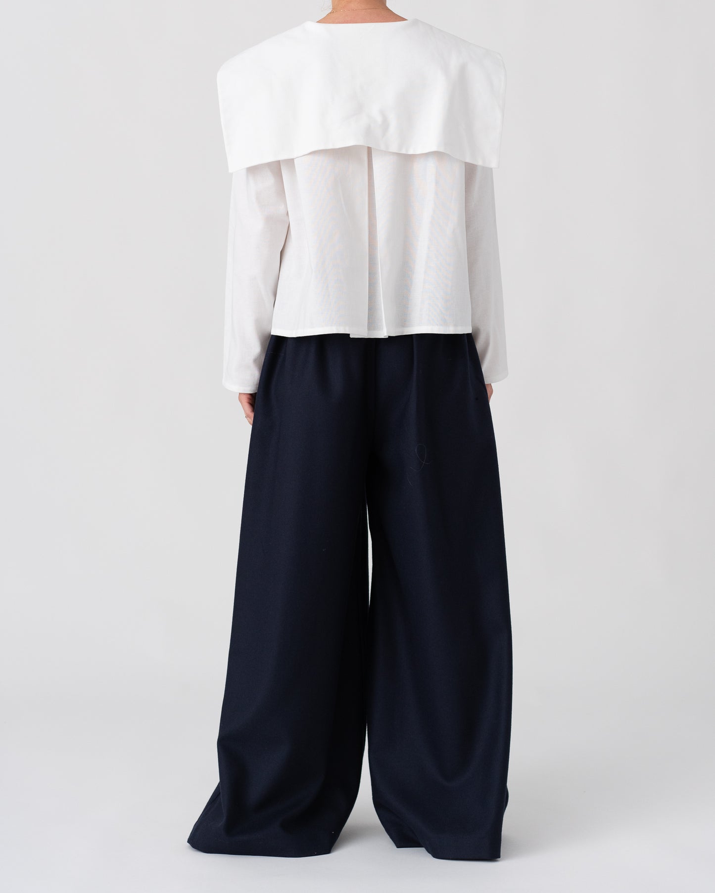 Model is wearing the Wool Black Pantalons by Les Vacances d’Irina, wide-leg handmade jersey-knit wool pants with adjustable drawstring waist and side pockets, available at House of Woven Stories.